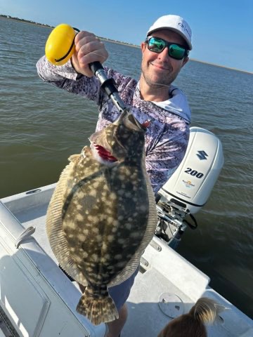 Angler holding up a big flounder caught on a Down South lure
