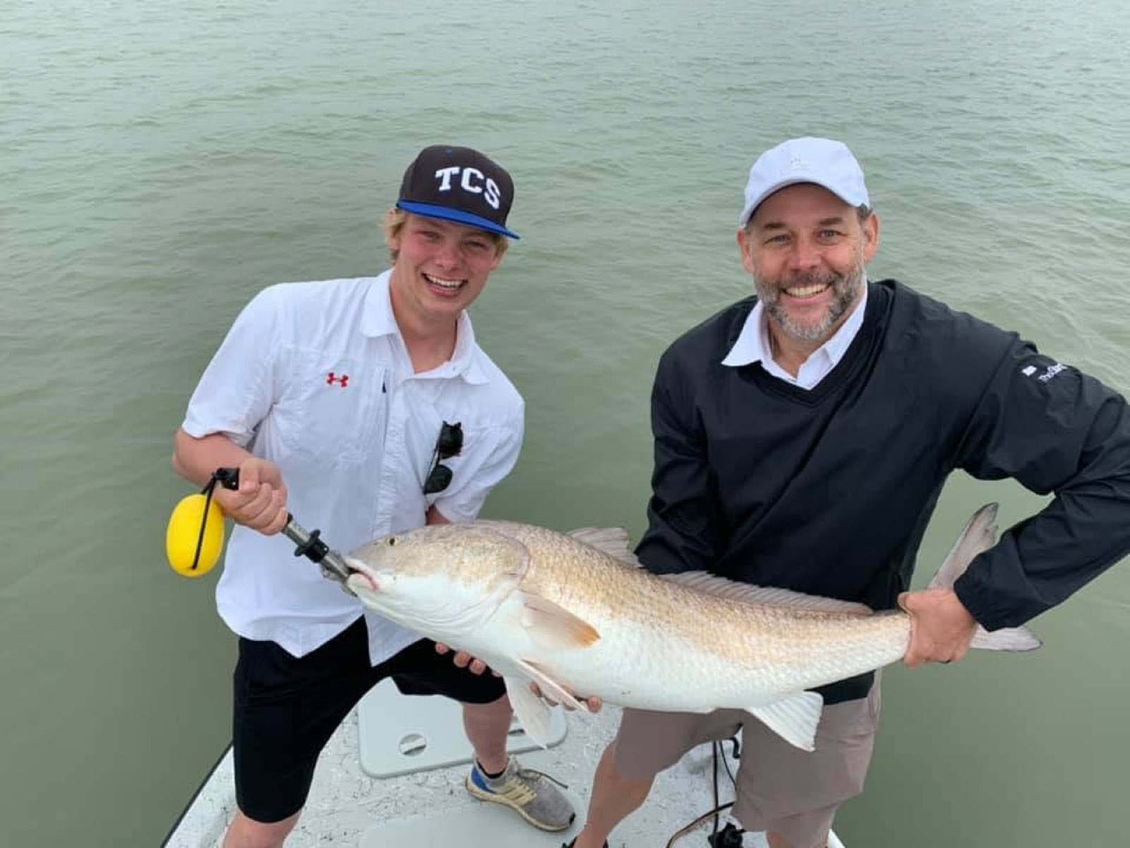 Angler and the captain with a bull redfish