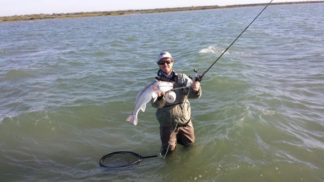 Wading angler fighting a fish