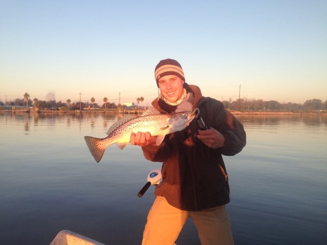Angler with a speckled trout at sunset