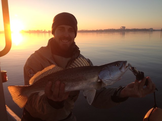 Angler with a speckled trout at sunrise