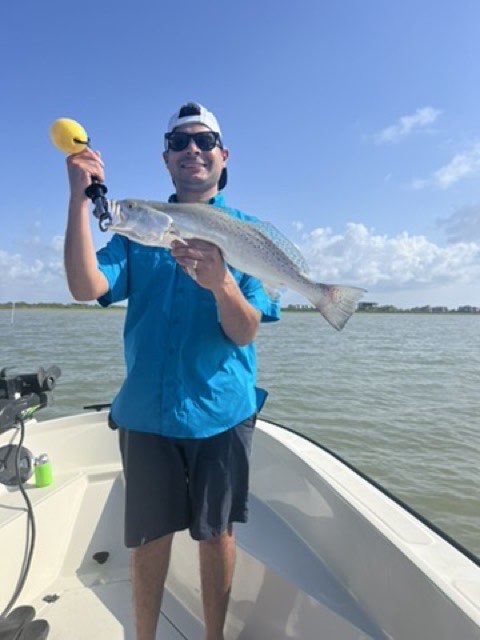 Angler in a blue shirt with a speckled trout