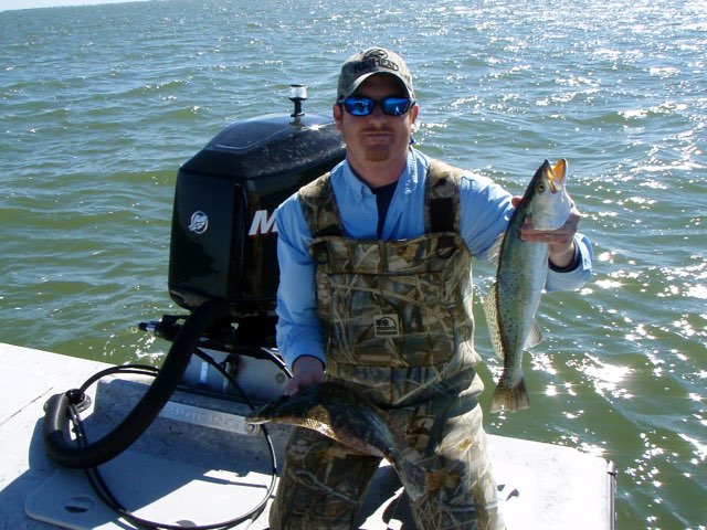 Angler in waders with a speckled trout