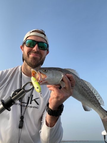 Angler with a speckled trout caught on topwater