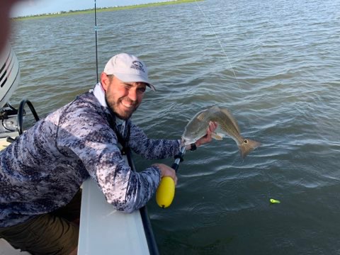 Angler landing a fish caught on topwater
