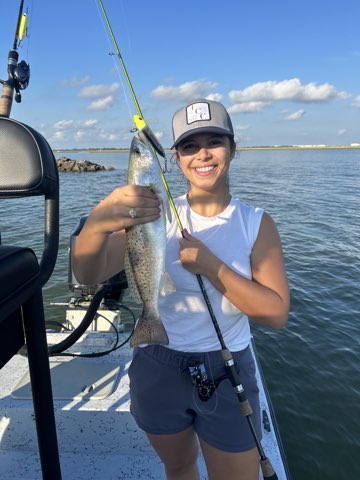 Angler with a speckled trout caught on topwater