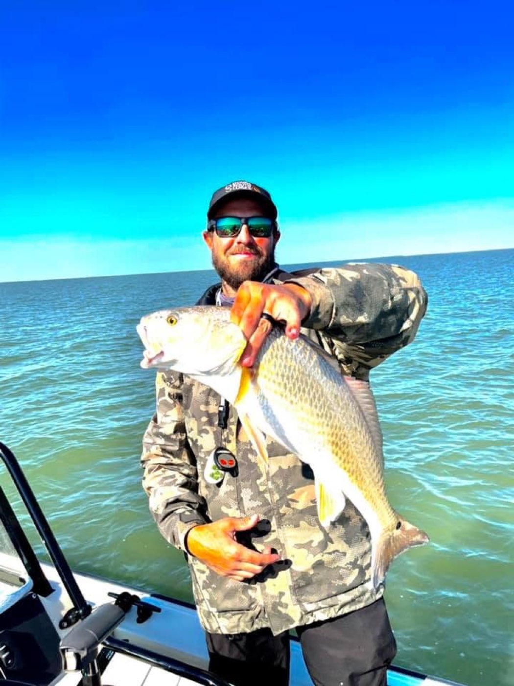 Angler holding up a redfish caught on topwater